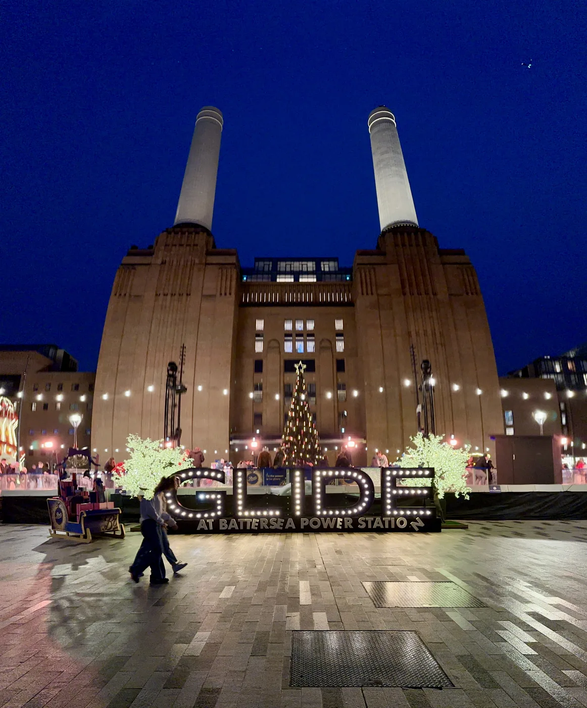 The entrance to Glide at Battersea Power Station on 23 December 2024, with the rink's Christmas tree in front of the power station